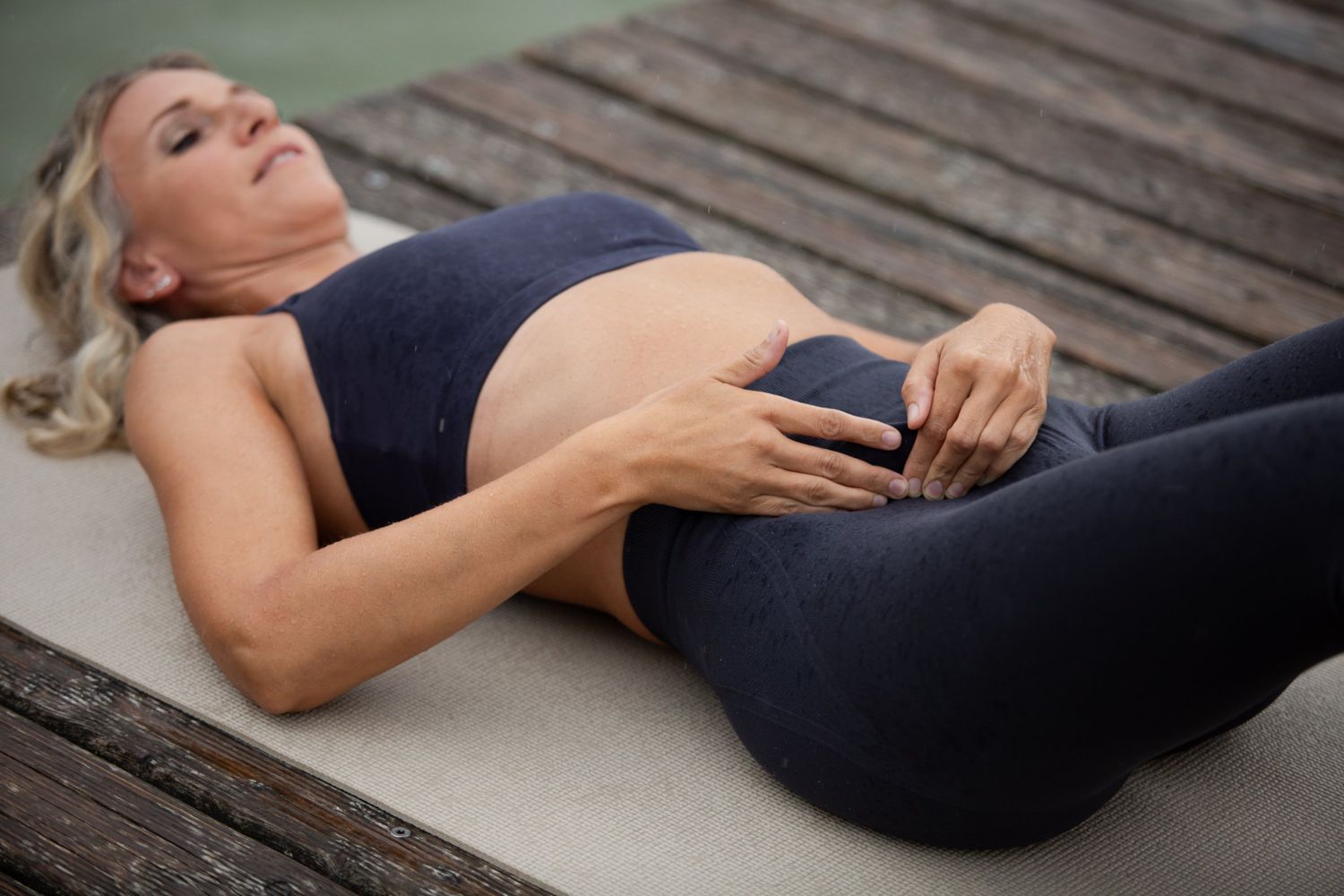 Nina Wassinger zeigt eine sanfte Selbsthilfe-Technik am Bauch im Liegen